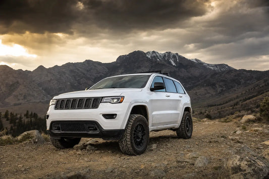 Jeep Grand Cherokee EcoDiesel on off-road trail with rocky terrain and mountain backdrop
